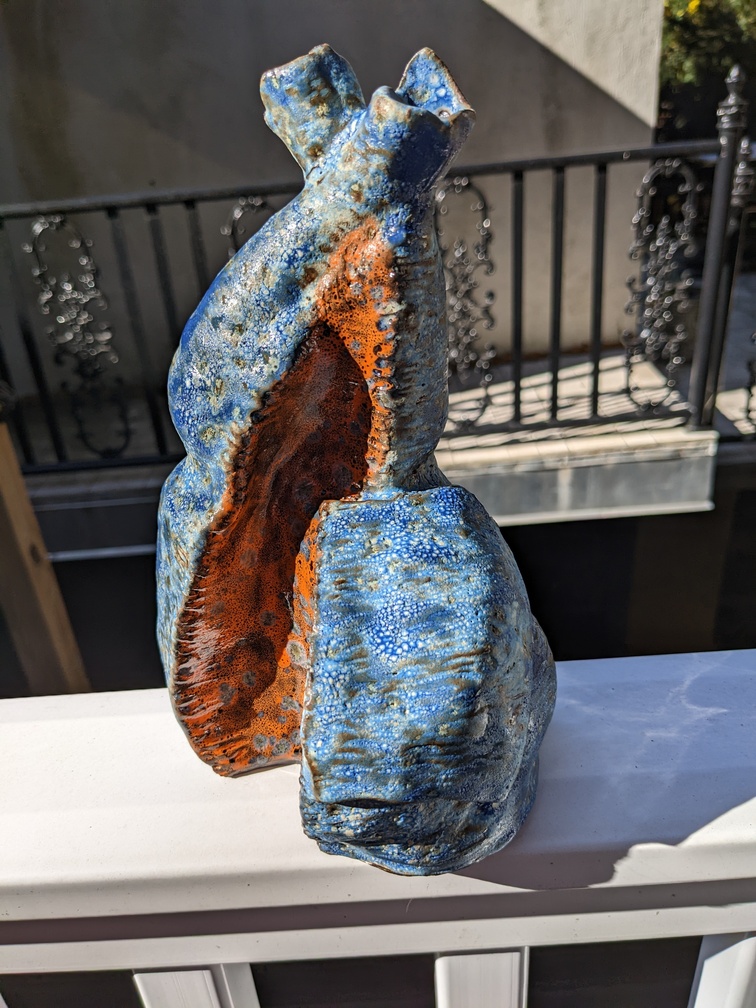 A blue and orange ceramic vase with two necks